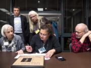 Liz Cline, from left in foreground, Katia Delavar and Jim Karlock tally votes for the top three nominees to fill the empty county council seat while witnesses watch during the Clark County Republican Party Central Committee’s meeting.