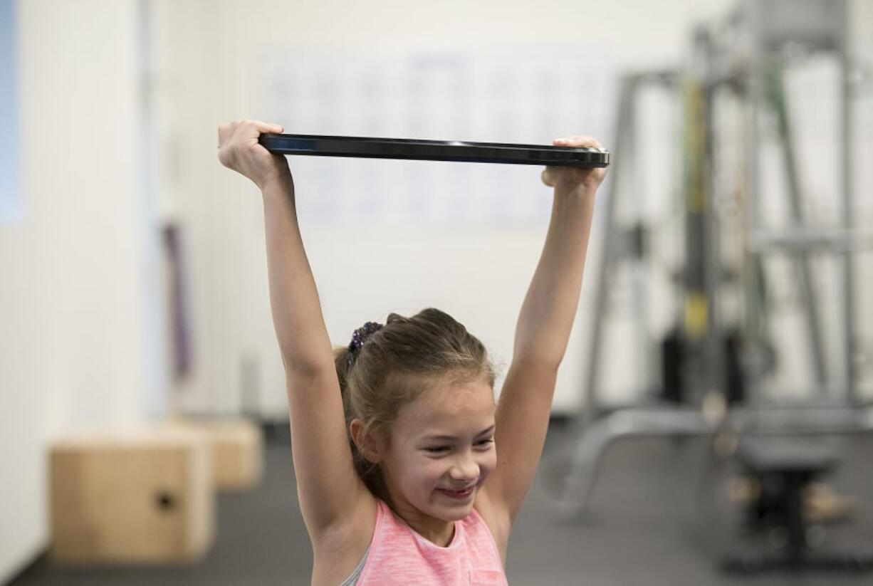 Richelle Endres, 10, of La Center shows her strength during a kids fitness class at Salmon Creek Bridge Chiropractic.