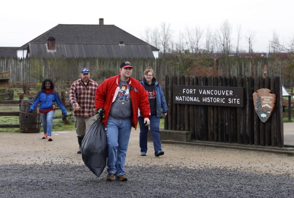 The Sudbeck family of Camas, left to right, Kat, Kevin, James and Helen, collect trash at Fort Vancouver National Historic Site. They were one of two groups out picking up garbage at Fort Vancouver on Saturday due to the partial government shutdown.