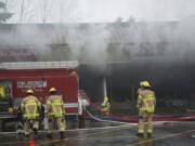 Firefighters from Fire District 6, Vancouver Fire Department and Clark County Fire and Rescue responded to the three-alarm fire Saturday at Holly Park Shopping Center in Hazel Dell.