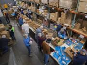 A long line of boxes line the warehouse at FISH Westside Food Pantry of Vancouver as volunteers sort through donated food for low-income residents Monday morning. Operations Manager Wendy Bukaski said she’s concerned that misinformation surrounding a changed SNAP benefit schedule linked to the federal government shutdown could lead to a hectic February at the food pantry.