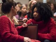 Jamie Carstensen, a paraeducator at Hudson’s Bay High School, left, speaks with Chipo Sowards, a library Clerk at Hudson’s Bay High School, shortly before a strike vote during a Vancouver Association of Educational Support Professionals meeting on Tuesday night. The VAESP represents more than 700 classified staff, including paraeducators, clerks and secretaries.