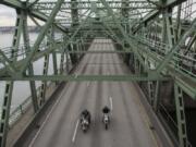 Two motorcycles drive North along the Interstate 5 Bridge.