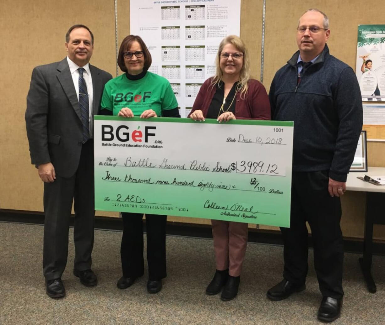 Battle Ground: Battle Ground Public Schools Superintendent Mark Ross, from left, accepts a check to purchase two automated external defibrillators from Battle Ground Education Foundation President Colleen O’Neal, CAM Academy Assistant Principal Julie Williamson and Mitch Thompson, the district’s director of business and risk management.