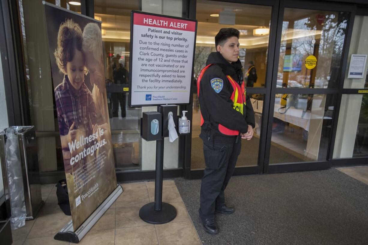 A hospital security worker, who declined to be identified, stands at a door at PeaceHealth Southwest Medical Center in Vancouver while screening for visitors under 12 years old and those who have not been vaccinated for measles as part of the hospital’s measles outbreak protocol. Children, especially kids under 5, are especially vulnerable to contracting measles.