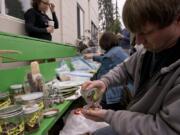 Jason Bringman of Vancouver grabs some seeds during a seed swap Sunday at the North County Community Food Bank in Battle Ground.