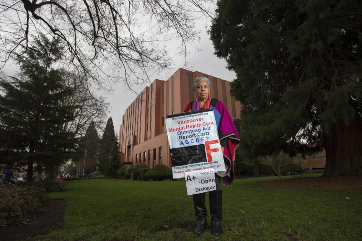 Cindi Fisher stands outside of the Clark County Courthouse holding a sign she’s used at protests for better mental health care.