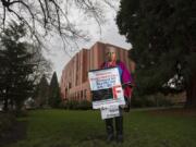 Cindi Fisher stands outside of the Clark County Courthouse holding a sign she’s used at protests for better mental health care.