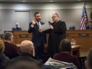 Councilor Erik Paulsen takes the oath of office and is sworn in to the Vancouver City Council by Clark County Superior Court Judge David Gregerson on Monday.