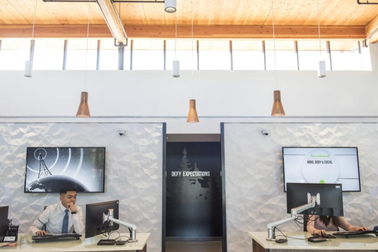 Teller Jan Carlo Dequiroz works at his station inside the HAPO Credit Union on Mill Plain Boulevard. The building’s design captures natural light and the lighting fixtures adjust their output based on the time of day.