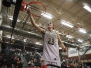 Union’s Ethan Smith (23) cuts a piece of the basketball net after defeating Skyview in Wednesday night’s game and securing the 4A Greater St. Helens League title at Union High School on Jan. 30, 2019. Union won 72-55.