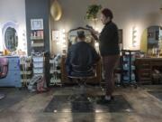 One of the perks of being an independent hairstylist is getting to pick your clients. Shelby Oxley cuts the hair of her husband, Barry Oxley, at the station she rents in Marquee Salon + Studio.