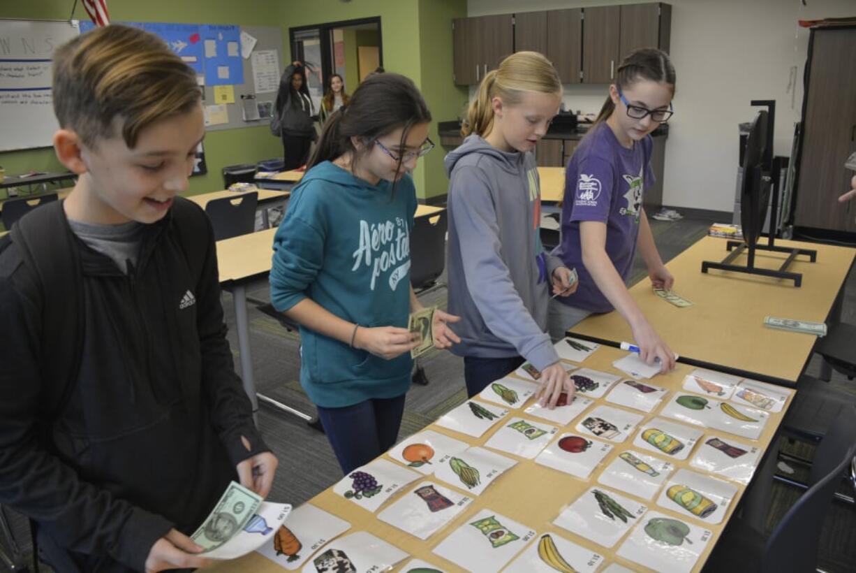 Washougal: Jemtegaard Middle School students, from left, Carson Kansler, Gracie Miller, Danica Stinchfield and Brooklyn Chase, play the Budget Game at an iQ Credit Union workshop for students in the Club 8 after-school program.