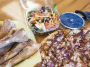 Cinnamon sugar sticks, from left, the garden salad and a Half & Half Signature Pizza combination of the Dough Boys Classic Cheese and Memphis BBQ.