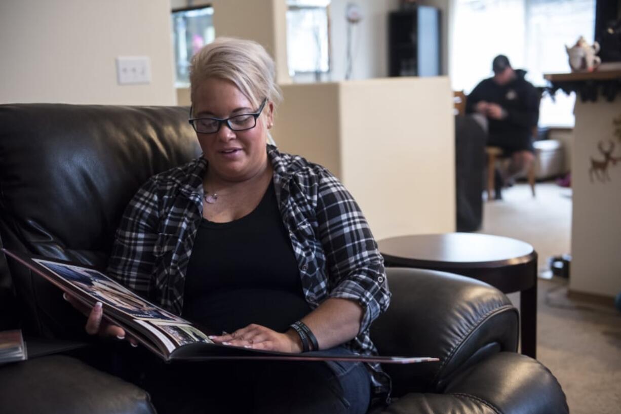 Angela Daniels looks at a photo of her son, Damian Daniel Rodriguez, 23, from a mud race they ran together a few months before his schizophrenia diagnosis, at her Vancouver home.