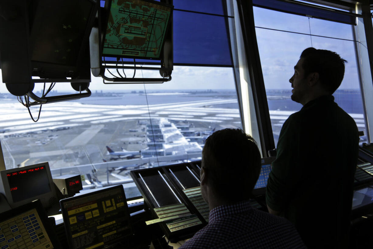 FILE - In this March 16, 2017, file photo, air traffic controllers work in the tower at John F. Kennedy International Airport in New York. The partial government shutdown is starting to effect air travelers. Over the weekend, some airports had long lines at checkpoints, apparently caused by a rising number of security officers calling in sick while they are not getting paid.