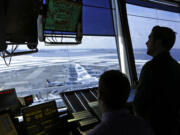 FILE - In this March 16, 2017, file photo, air traffic controllers work in the tower at John F. Kennedy International Airport in New York. The partial government shutdown is starting to effect air travelers. Over the weekend, some airports had long lines at checkpoints, apparently caused by a rising number of security officers calling in sick while they are not getting paid.