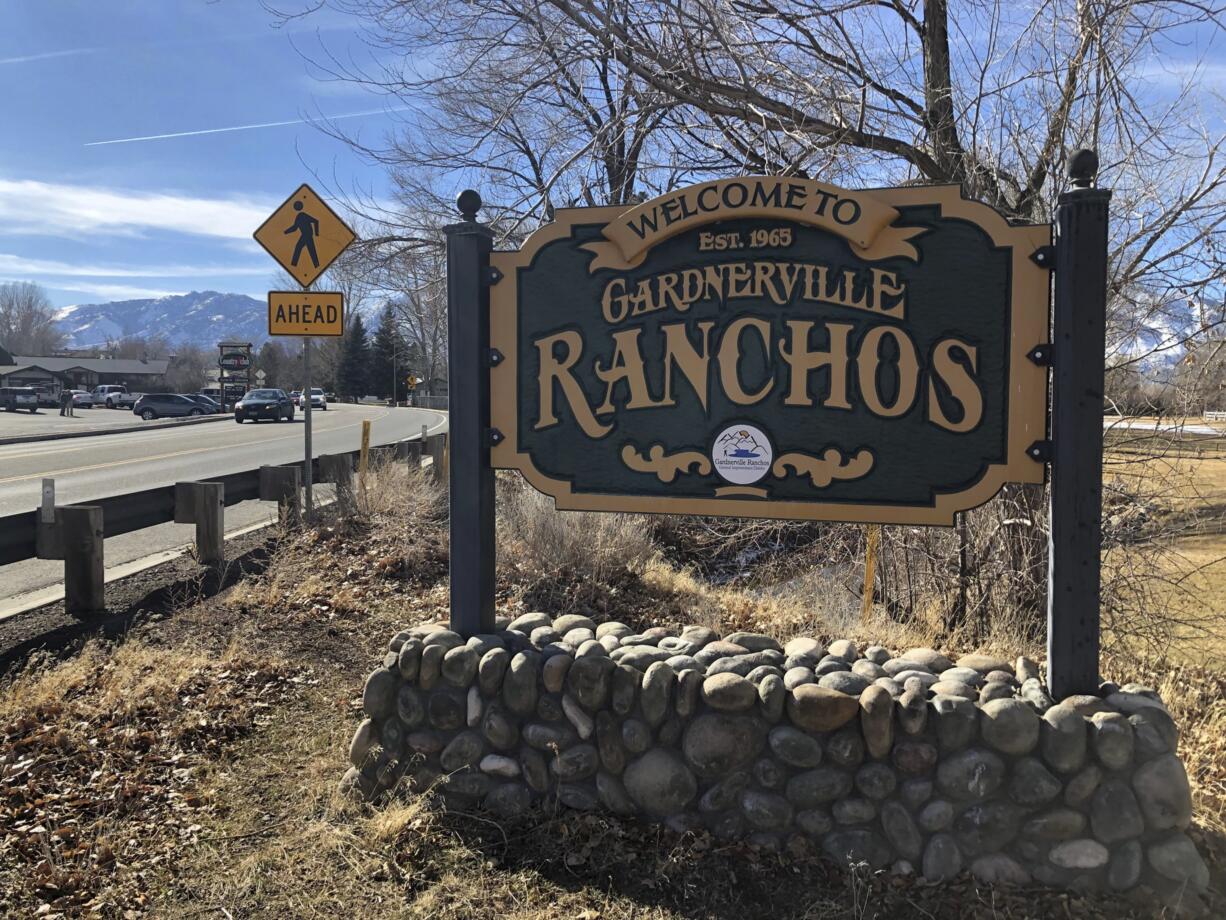 A welcome sign sits at the entrance to the tight tight-knit community of Gardnerville Ranchos, Nev., Wednesday, Jan. 23, 2019, where two women were recently found dead in their homes. The killings of the two women and a couple up north in Reno that police say were committed by a man in the U.S. illegally have put the community on edge. (AP Photo/Michelle L.