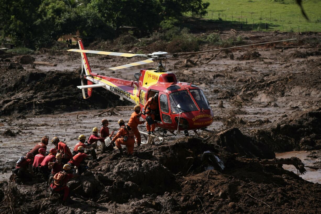 Firefighters are resupplied as they search for victims of a dam collapse in Brumadinho, Brazil, Monday, Jan. 28, 2019. Firefighters on Monday carefully moved over treacherous mud, sometimes walking, sometimes crawling, in search of survivors or bodies four days after a dam collapse that buried mine buildings and surrounding neighborhoods with iron ore waste.