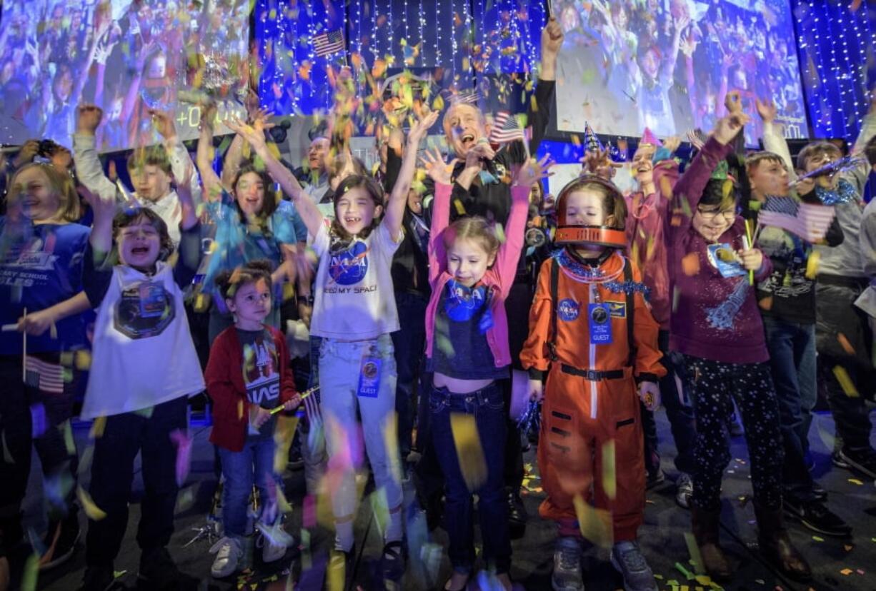 New Horizons principal investigator Alan Stern, of the Southwest Research Institute in Boulder, Colo., center, celebrates with school children at the exact moment that the New Horizons spacecraft made the closest approach of Kuiper Belt object Ultima Thule, early Tuesday, Jan. 1, 2019, at Johns Hopkins University Applied Physics Laboratory in Laurel, Md.