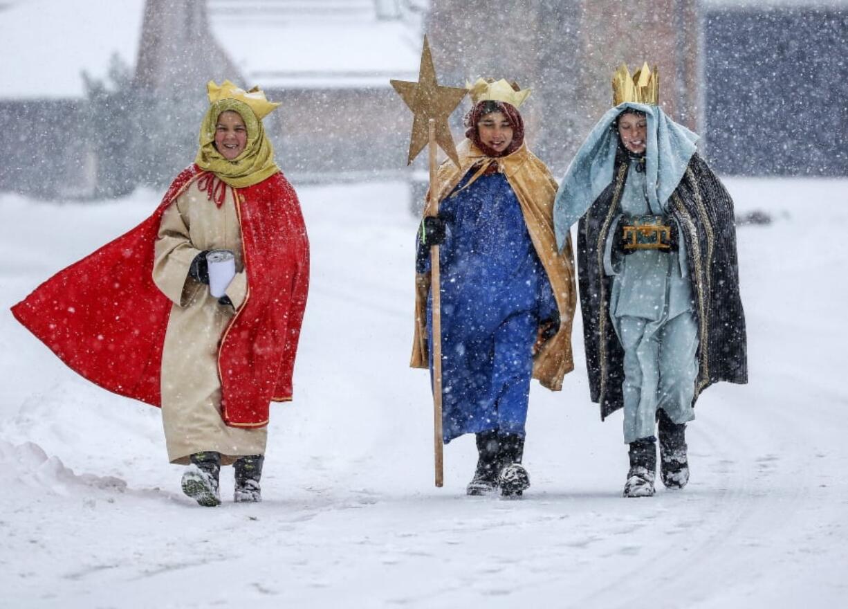 Coral singer in traditional costumes walk through the snow in Eglingen, southern Germany, Saturday, Jan. 5, 2019.