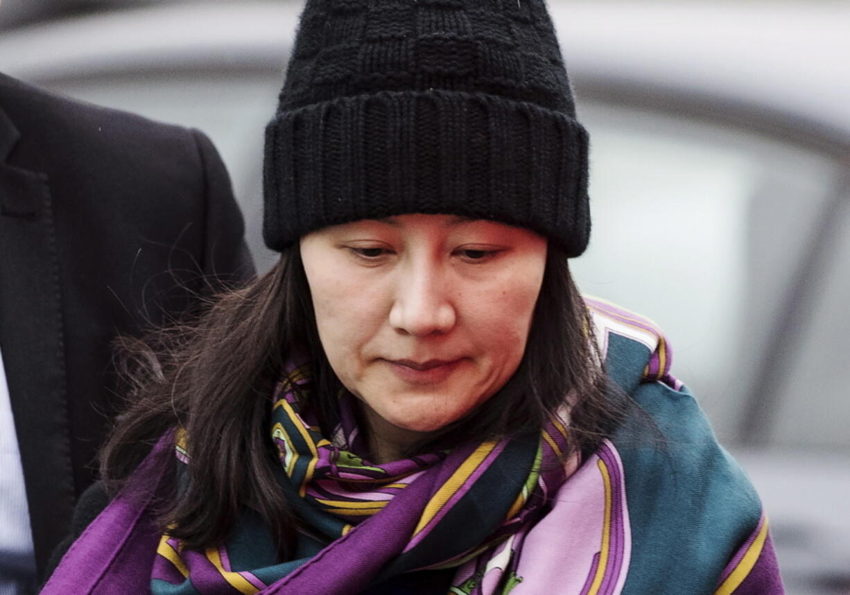 FILE - In this Dec. 12, 2018, file photo, Huawei chief financial officer Meng Wanzhou arrives at a parole office with a security guard in Vancouver, British Columbia. China on Tuesday, Jan. 22, 2019, demanded the U.S. drop a request that Canada extradite the top executive of the tech giant Huawei, shifting blame to Washington in a case that has severely damaged Beijing’s relations with Ottawa.