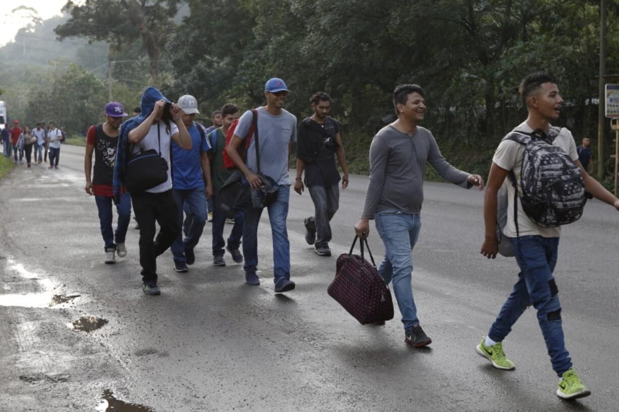 U.S.-bound migrants walk along the roadside as they leave Cofradia, Honduras, early Tuesday, Jan. 15, 2019. Yet another caravan of Central American migrants set out overnight from Honduras, seeking to reach the U.S. border following the same route followed by thousands on at least three caravans last year.