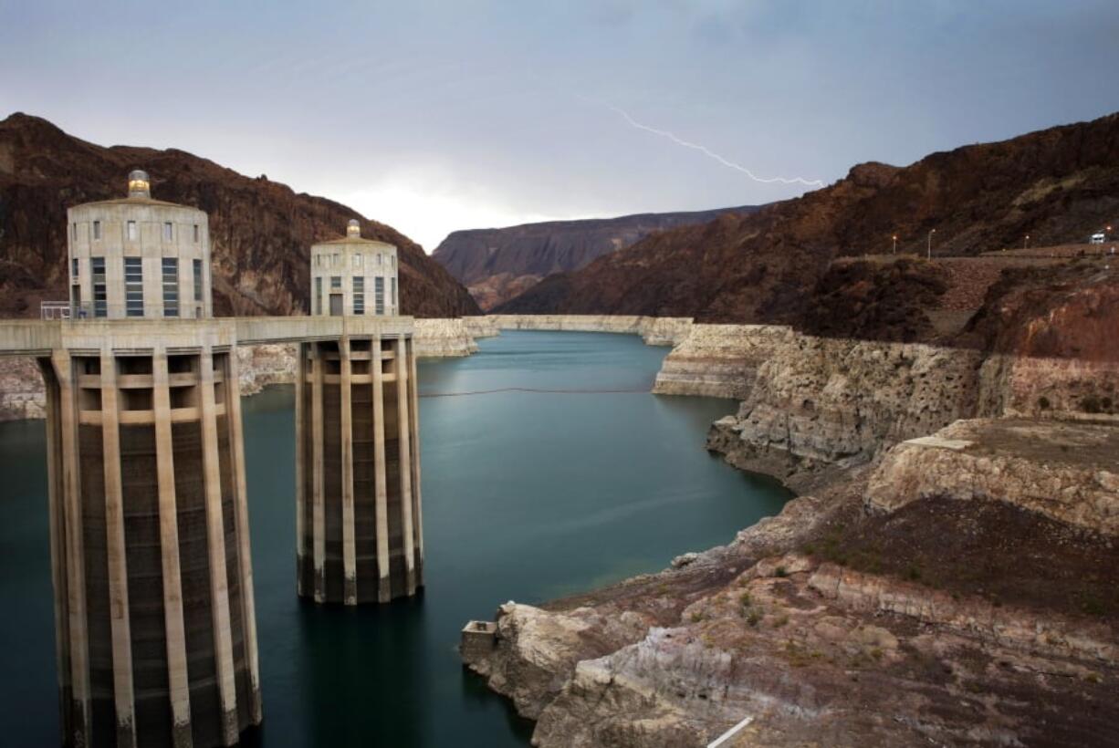 FILE - In this July 28, 2014, file photo, lightning strikes over Lake Mead near Hoover Dam that impounds Colorado River water at the Lake Mead National Recreation Area in Arizona. Arizona is nearing a deadline to approve a plan to ensure a key reservoir in the West doesn’t become unusable as a water source for farmers, cities, tribes and developers. Other Western states are watching. The U.S. Bureau of Reclamation expects full agreement on a drought contingency plan by Thursday, Jan. 31, 2019.