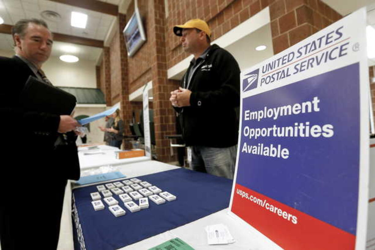 In this Nov. 2, 2017, file photo a recruiter from the postal service, right, speaks with an attendee of a job fair in the cafeteria of Deer Lakes High School in Cheswick, Pa. Even with fear of a global economic slump depressing stock markets, Friday, Jan. 4, 2019 jobs report for December is expected to offer reassurance that the U.S. economy remains sturdy and on track to expand for a 10th straight year.