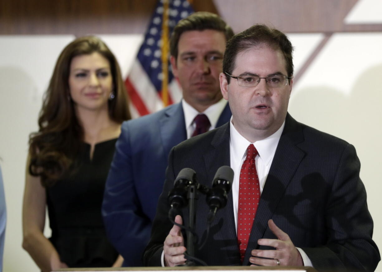 Former federal prosecutor and Miami appeals court judge Robert Luck, right, speaks after being appointed for a seat on the Florida Supreme Court by Republican Gov. Ron DeSantis, center, Monday, Jan. 14, 2019, in Miami.