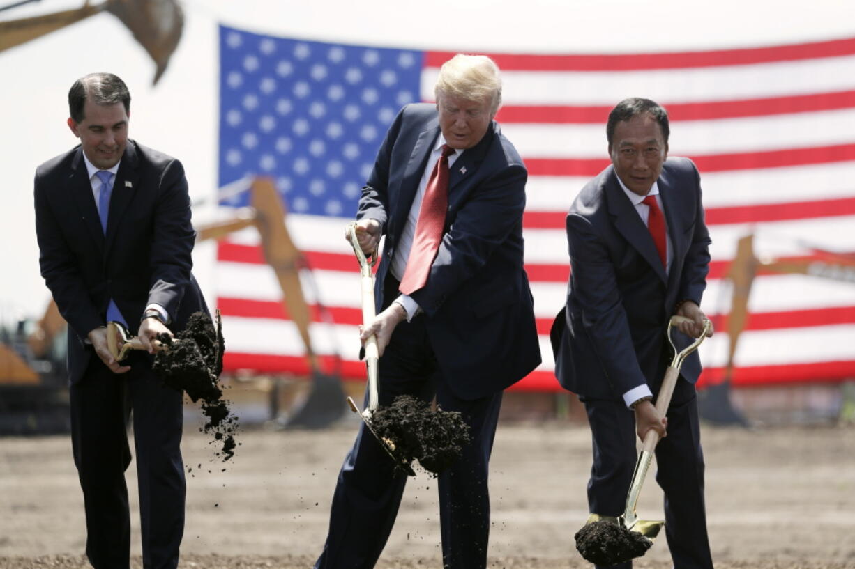 FILE - In this June 28, 2018, file photo, President Donald Trump, center, along with Wisconsin Gov. Scott Walker, left, and Foxconn Chairman Terry Gou participate in a groundbreaking event for the new Foxconn facility in Mt. Pleasant, Wis. Foxconn Technology Group said Wednesday, Jan. 30, 2019 it is shifting the focus of its planned $10 billion Wisconsin campus away from blue-collar manufacturing to a research hub, while insisting it remains committed to creating 13,000 jobs as promised.