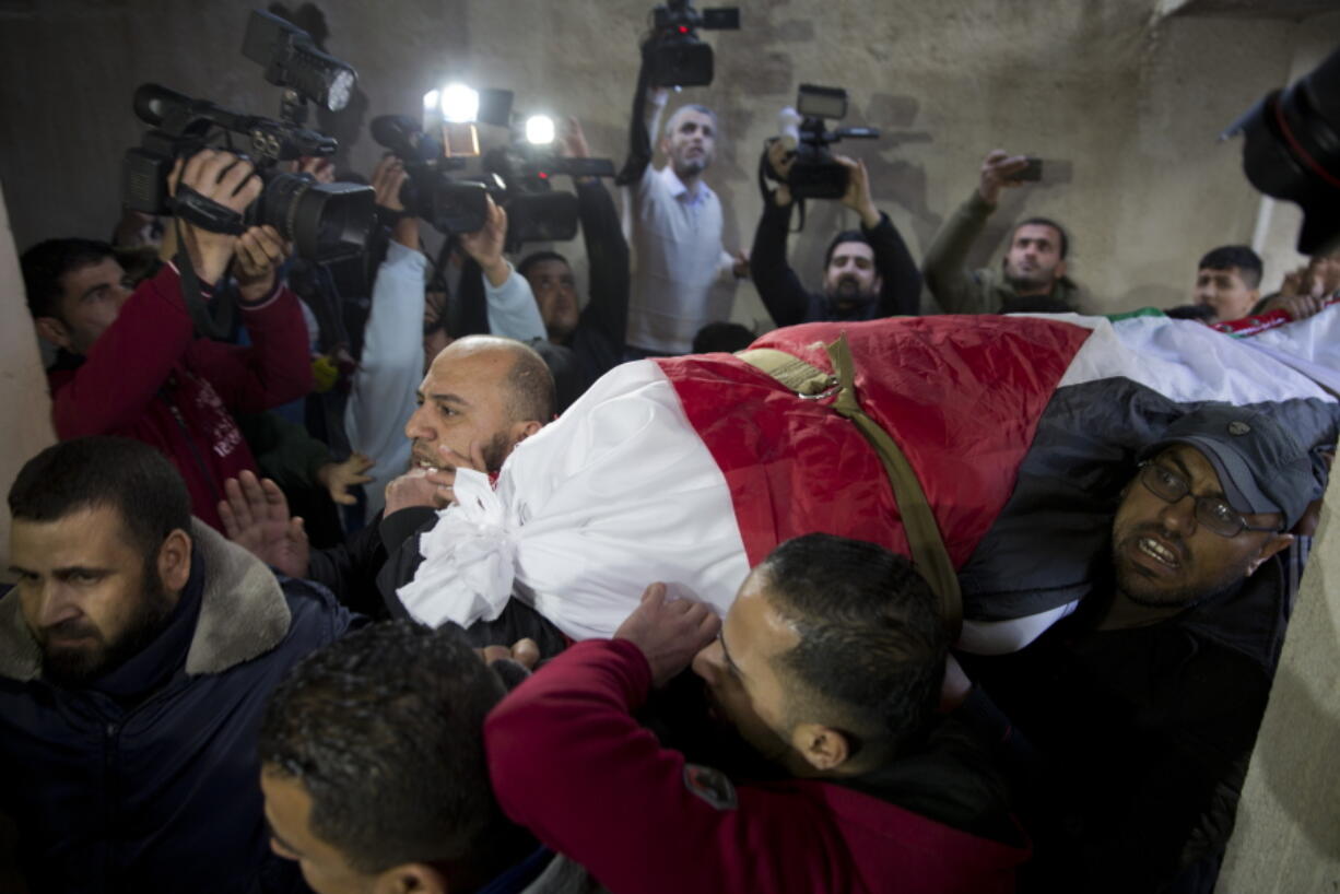 Mourners carry the body of Palestinian woman, Amal al-Taramsi, 43, who was killed by Israeli troops during Friday’s protest at the Gaza Strip’s border with Israel, into the family home during her funeral in Gaza City, Saturday, Jan. 12, 2019.