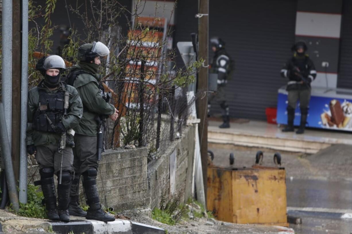 FILE - In this Wednesday, Jan. 9, 2019 file photo, Israeli forces deploy during a raid in the West Bank City of Ramallah. Israel has been launching raids into the heart of Ramallah, and the U.S. is cutting off aid and taking actions that many fear will obliterate any remaining hope for a two-state solution.