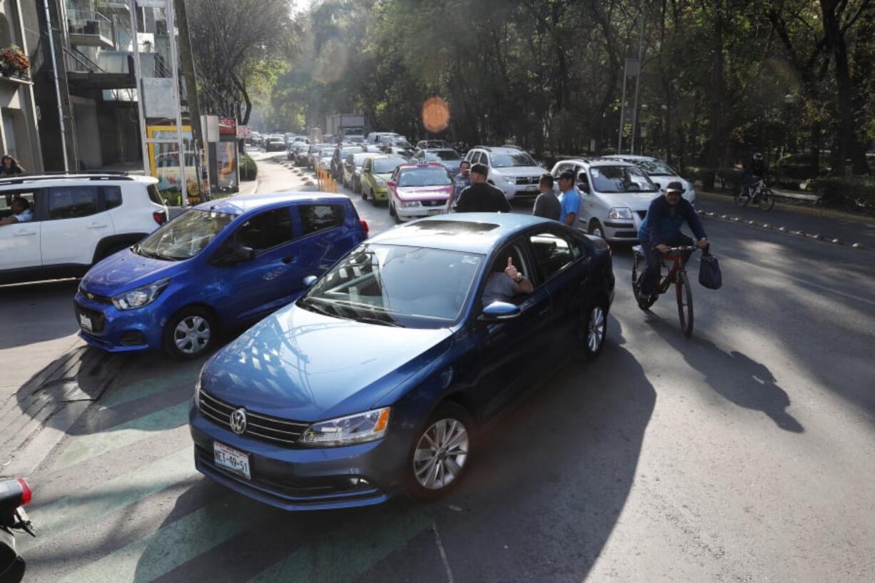 Drivers wait in line to fill up their tanks Wednesday at a gas station in Mexico, City.