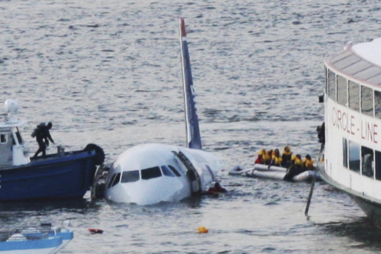 FILE - In this Jan. 15, 2009 file photo, a diver, left, aboard an NYPD vessel prepares to rescue passengers that escaped from the Airbus 320 US Airways aircraft made an emergency landing in the Hudson River in New York in what came to be known as the "Miracle on the Hudson" because everyone survived. It's been 10 years since US Airways flight 1549 landed on the Hudson River after colliding with a flock of geese just after takeoff.