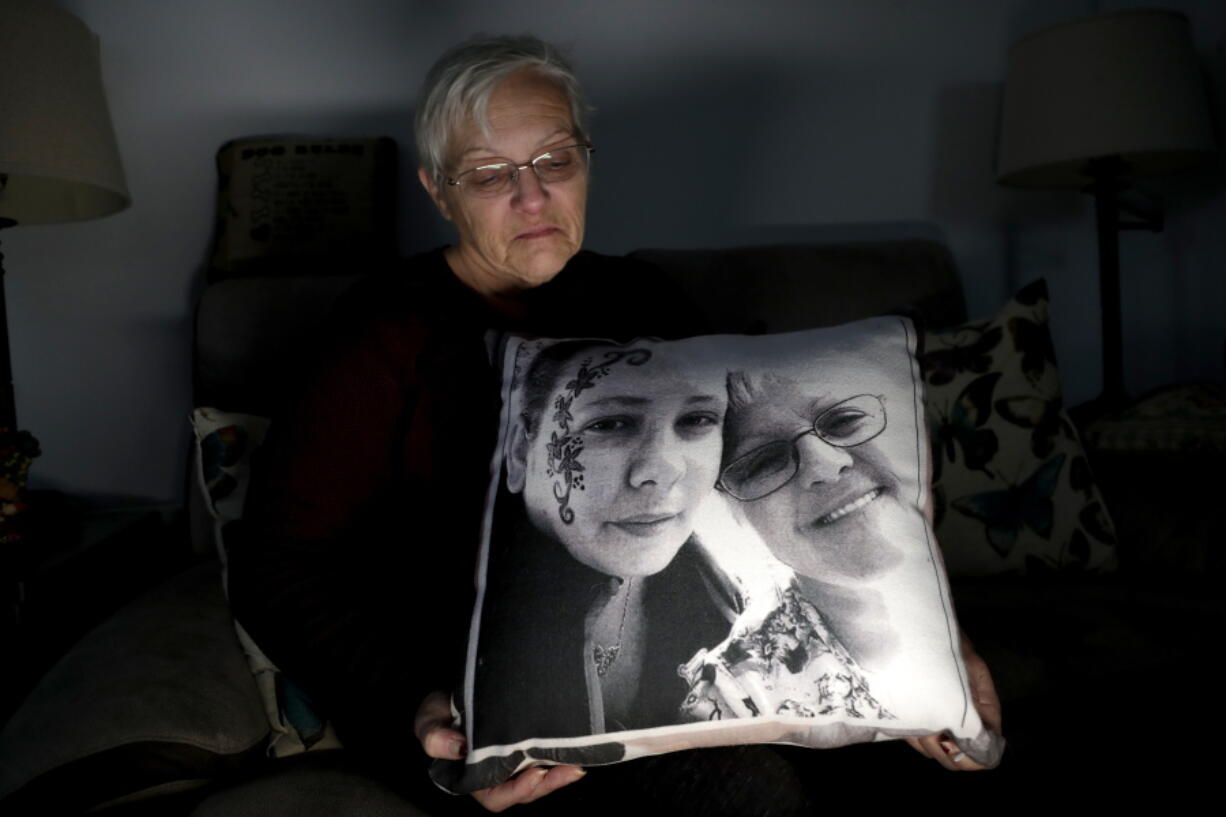 In a photo taken Friday, Jan. 18, 2019, Deborah Fuller poses for a photograph for The Associated Press with a pillow showing a photo of her late daughter, Sarah Fuller, left, who passed of a prescription drug overdose, and her during an interview in her home in West Berlin, N.J. The trial of a Insys Therapeutics Inc. founder John Kapoor, who accused of scheming to bribe doctors into prescribing a powerful painkiller, is putting a spotlight on the nation’s deadly opioid crisis.