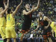 Oregon State’s Tres Tinkle, center, goes up to shoot between Oregon’s Paul White, left, Ehab Amin and teammate Gligorije Rakocevic, right, during the second half of an NCAA college basketball game Saturday, Jan. 5, 2019, in Eugene, Ore.