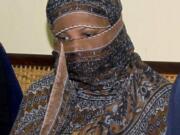 FILE - In this Nov. 20, 2010 file photo, Aasia Bibi, a Pakistani Christian woman, listens to officials at a prison in Sheikhupura near Lahore, Pakistan. Pakistan’s top court on Tuesday upheld its acquittal of Bibi, who had been sentenced to death for blasphemy, clearing the last legal hurdle and freeing her to leave the country in a move that dealt a blow to radical Islamists who had demanded her execution.