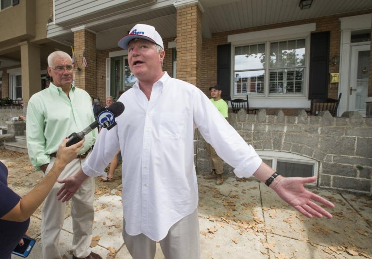 FILE - In this Aug. 5, 2016 file photo John Dougherty, right, makes some brief comments to the media, in Philadelphia. The powerful union boss who has held a tight grip on construction jobs and politics in the Philadelphia region and beyond has been indicted in an FBI probe along with a city councilman and at least six others. Federal prosecutors say Dougherty used union funds as “his own personal bank account.” Dougherty leads the International Brotherhood of Electrical Workers Local 98, along with the city’s Building Trades Council. He has been at the helm of the century-old electricians union for 25 years.