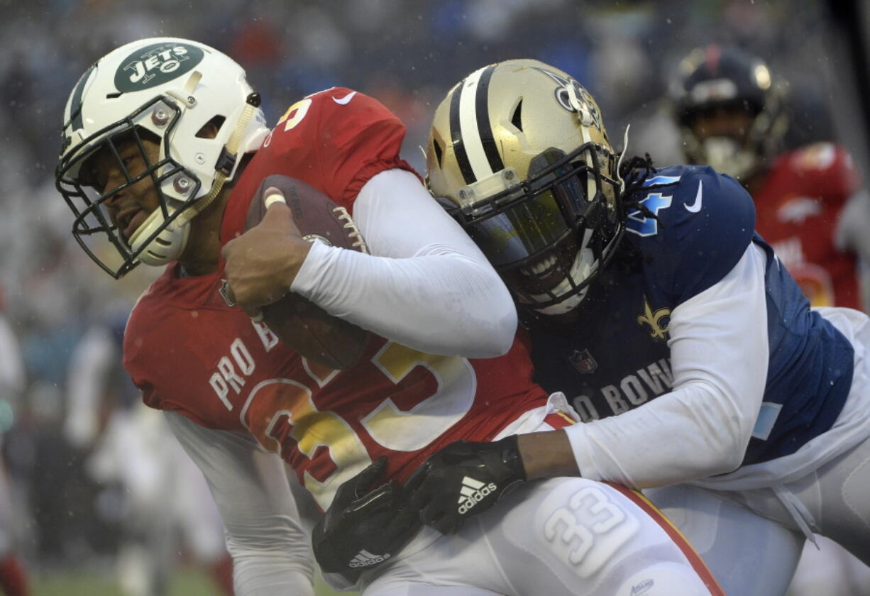 AFC safety Jamal Adams (33), of the New York Jets, is stopped by NFC running back Alvin Kamara (41), of the New Orleans Saints, after intercepting a pass during the second half of the NFL Pro Bowl football game Sunday, Jan. 27, 2019, in Orlando, Fla.