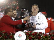 Ohio State coach Urban Meyer, right, holds the trophy after the team's 28-23 win over Washington in the Rose Bowl NCAA college football game Tuesday, Jan. 1, 2019, in Pasadena, Calif. (AP Photo/Jae C.