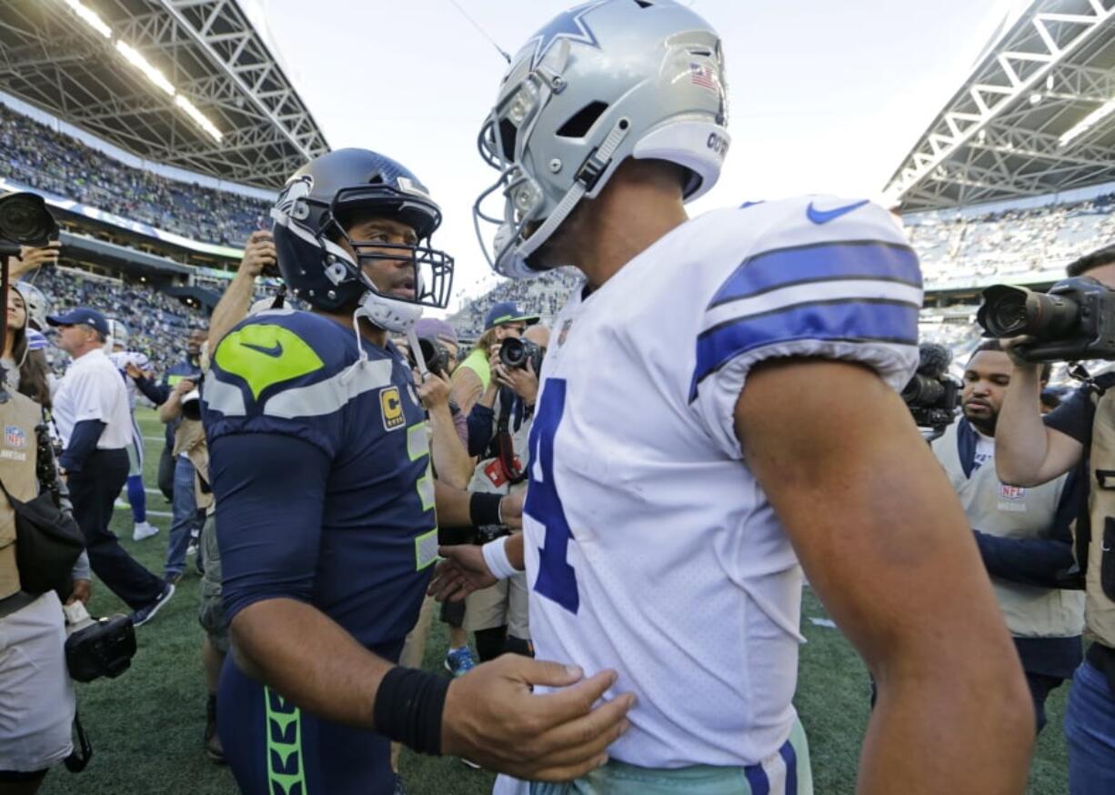 Seattle Seahawks quarterback Russell Wilson, left, greets Dallas Cowboys quarterback Dak Prescott, right, following their game on Sept. 23, 2018 in Seattle.