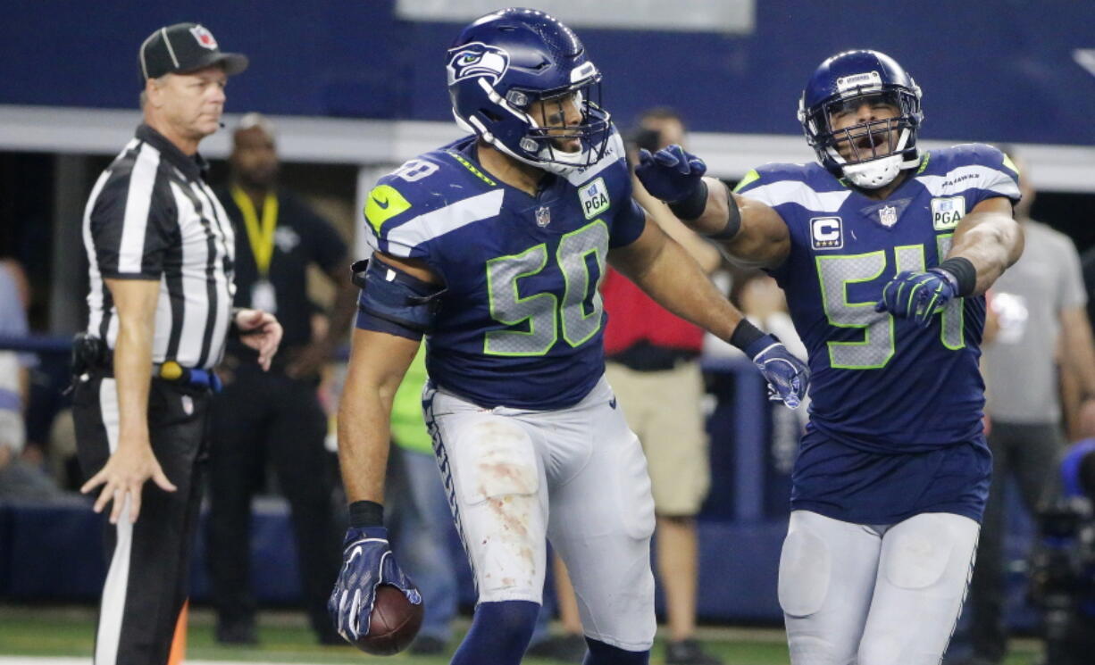 Seattle Seahawks’ K.J. Wright (50) and Bobby Wagner (54) celebrate an interception against Dallas Cowboys quarterback Dak Prescott during the second half of the NFC wild-card NFL football game in Arlington, Texas, Saturday, Jan. 5, 2019.