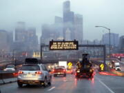 Rush hour northbound Highway 99 traffic backs-up Jan. 3 while heading toward the Alaskan Way Viaduct just ahead as a sign overhead advises of an upcoming closure of the roadway in Seattle.