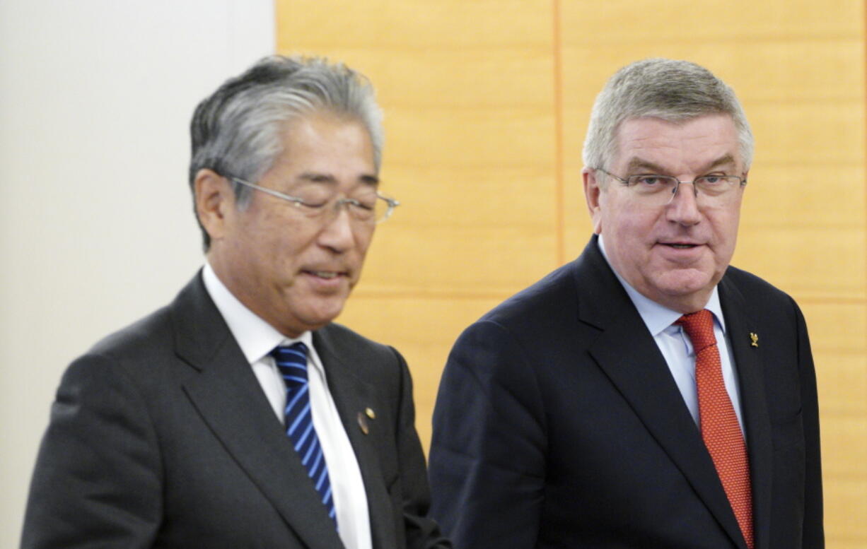 FILE - In this Nov. 30, 2018, file photo, International Olympic Committee (IOC) President Thomas Bach, right, escorts Japanese Olympic Committee (JOC) President Tsunekazu Takeda during an IOC Executive Board meeting in Tokyo. France’s financial crimes office says International Olympic Committee member Takeda is being investigated for corruption related to the 2020 Tokyo Olympics. The National Financial Prosecutors office says Takeda, the president of the Japanese Olympic Committee, was placed under formal investigation for “active corruption” on Dec.