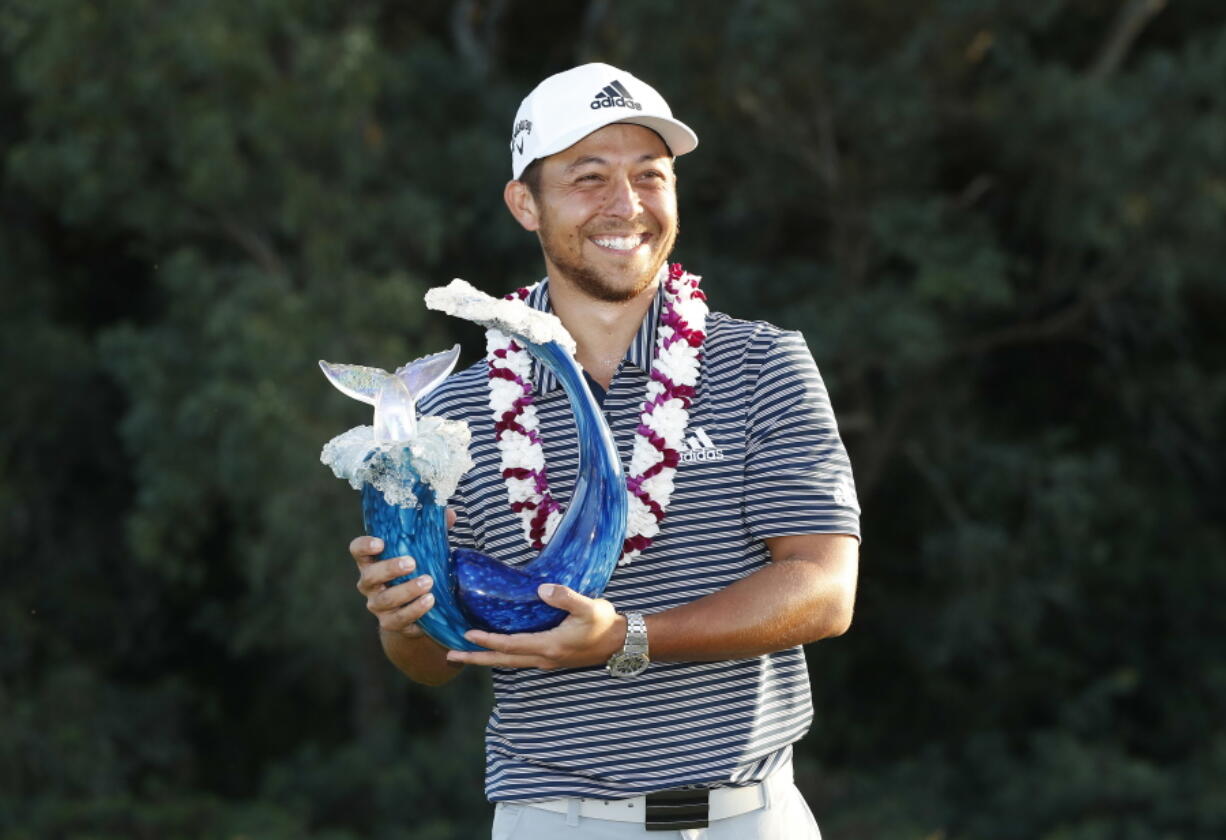 Xander Schauffele holds the champions trophy after the final round of the Tournament of Champions golf event, Sunday, Jan. 6, 2019, at Kapalua Plantation Course in Kapalua, Hawaii.