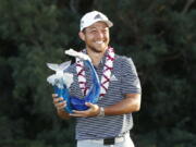 Xander Schauffele holds the champions trophy after the final round of the Tournament of Champions golf event, Sunday, Jan. 6, 2019, at Kapalua Plantation Course in Kapalua, Hawaii.