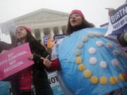 FILE - In this March 25, 2015 file photo, Margot Riphagen of New Orleans, La., wears a birth control pills costume during a protest in front of the U.S. Supreme Court in Washington. A U.S. judge will hear arguments Friday, Jan. 11, 2019, over California’s attempt to block new rules by the Trump administration that would allow more employers to opt out of providing no-cost birth control to women. The new rules are set to go into effect on Monday, Jan. 14, 2019.