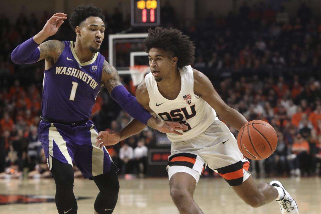 Oregon State's Ethan Thompson, right, is guarded by Washington's David Crisp (1) during the first half of an NCAA college basketball game in Corvallis, Ore., Saturday, Jan. 26, 2019.