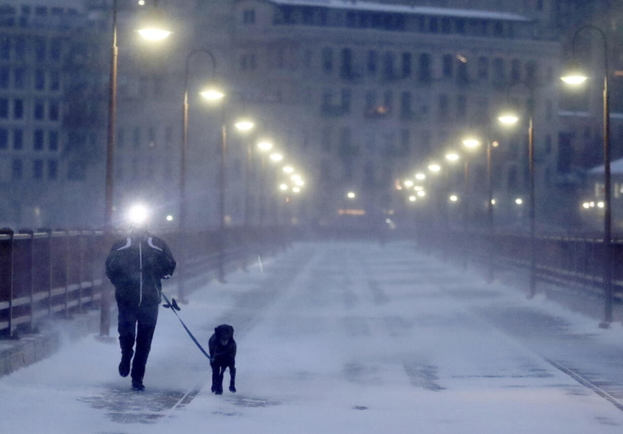 A runner and his dog brave frigid conditions Thursday while making their way east across the Stone Arch Bridge in Minneapolis.